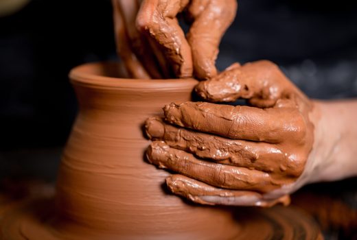 Hands of potter making clay pot, closeup photo